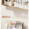 White cosmetic organizer with raised edges holding various beauty products on a wooden shelf and a counter.