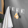 A white towel hangs on a gray wall featuring three silver adhesive hooks for heavy-duty organization.