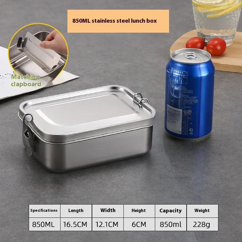 Une boîte à lunch en acier inoxydable argenté est montrée à côté d'une boîte de conserve et d'un bloc-notes assorti, détailla
