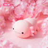 A pink cute axolotl night light with touch control and USB rechargeable battery resting on pink floral petals.