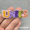 Embroidered iron-on patches spelling UNITE in various colors purple green orange and pink on a hand