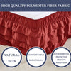 A close-up of a rust-colored polysdter fiber fabric ruffle skirt designed to wrap around a mattress.
