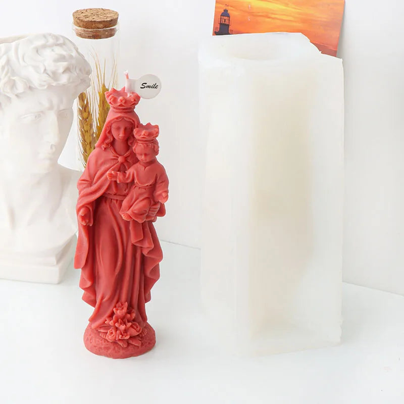 A reddish-pink silicone mold depicting a mother and child, used for religious candle and resin crafting.
