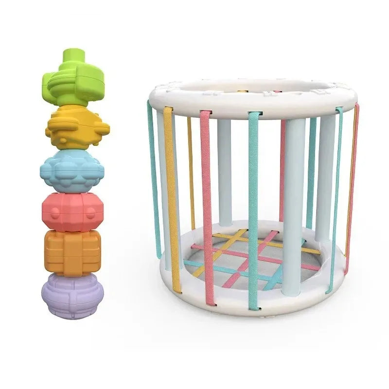 A rainbow shape sorter cube with soft elastic bands featuring colorful geometric shapes for Montessori learning.