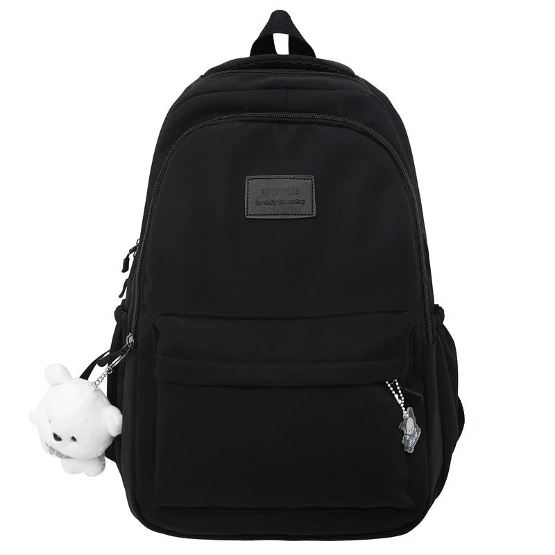 Black waterproof nylon laptop backpack featuring a small white charm.