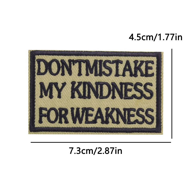 A rectangular embroidered patch with dark blue text on a tan background that reads DON'T MISTAKE MY KINDNESS FOR WEAKNESS