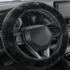 A close-up view of a black winter plush steering wheel cover on a car's steering wheel.