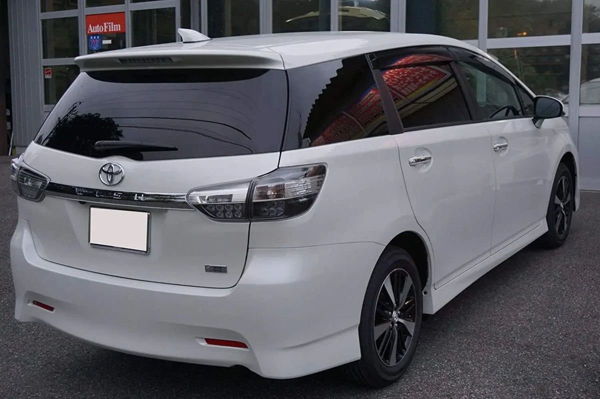 A white Toyota Prius minivan with dark window tint parked outdoors.