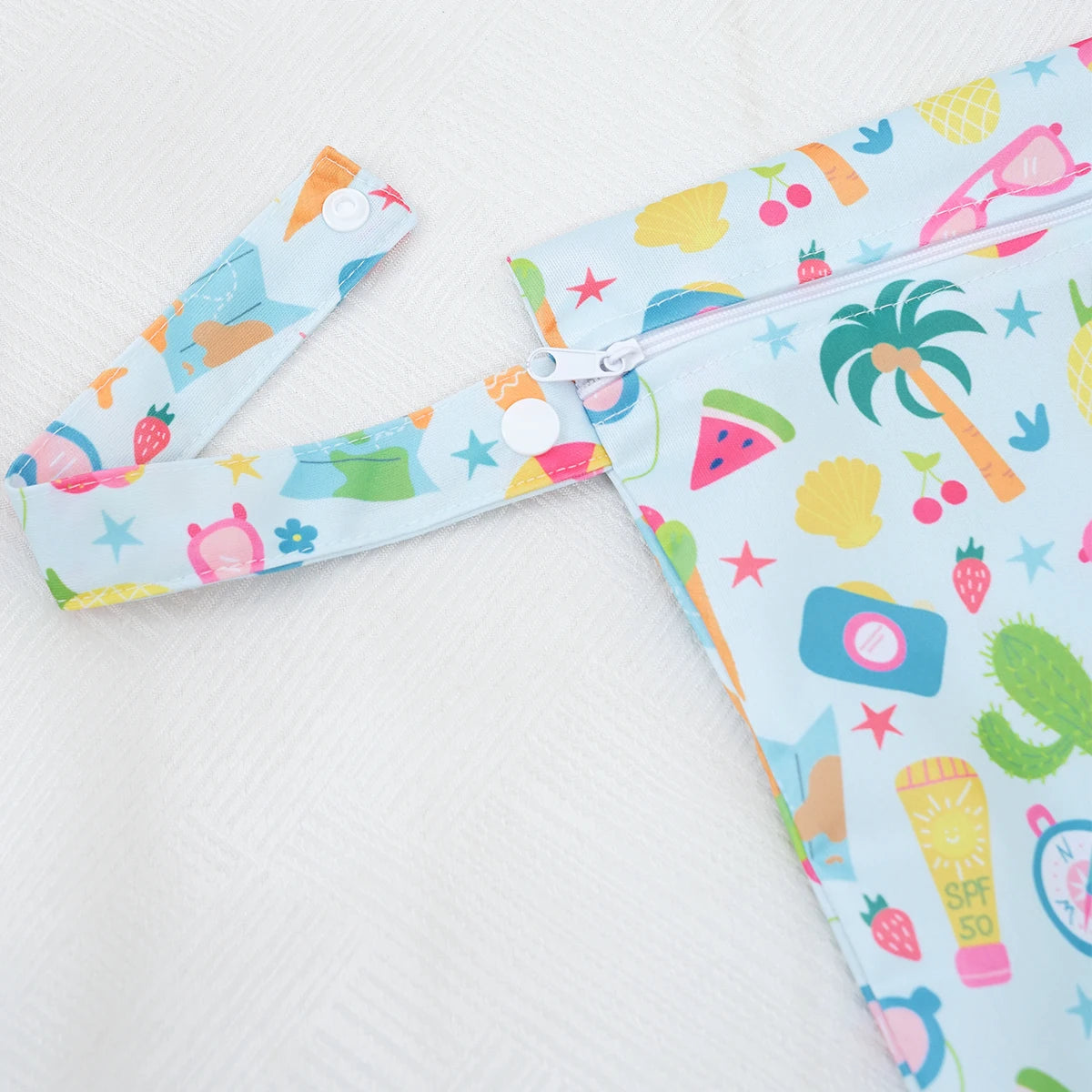 A light blue and colorful patterned mini waterproof wet dry bag for baby with a zipper.