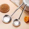 Stainless steel fine mesh skimmer spoon used for removing oil and foam, placed next to whole coriander seeds.