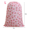 Pink drawstring laundry bag with a cherry pattern, shown from the front.