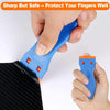 A hand is holding a blue plastic razor scraper with orange blades, demonstrating its use on fabric.