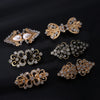 A collection of vintage gold and silver floral swirl clips for decorating cardigans and shawls
