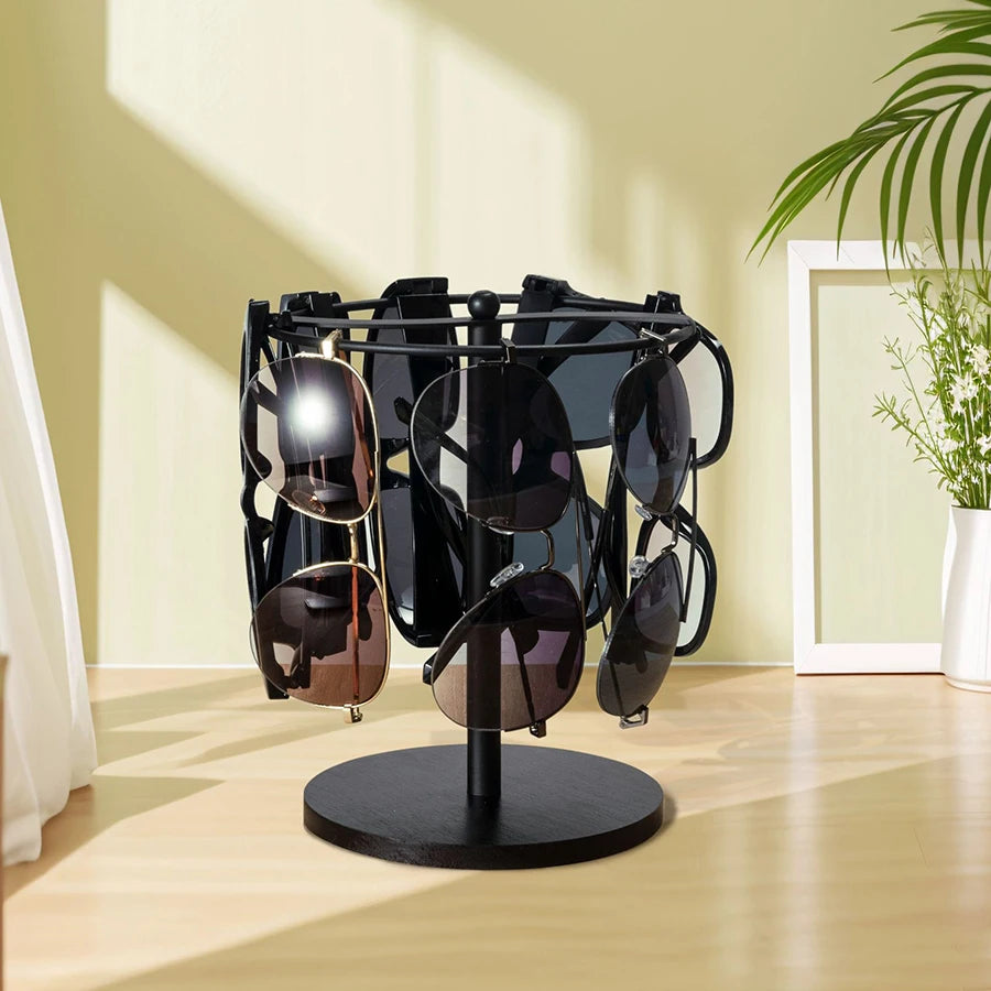 A black sunglasses organizer stand with a wooden base is displayed in a bright room.