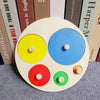 Un manipulateur Montessori rond en bois avec cinq cercles colorés : jaune, bleu, rouge, vert et orange.