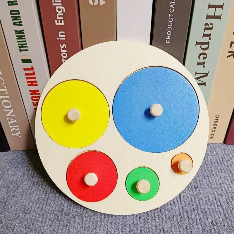 Un manipulateur Montessori rond en bois avec cinq cercles colorés : jaune, bleu, rouge, vert et orange.