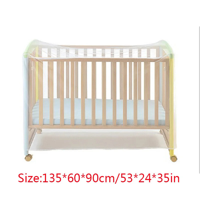 A wooden baby crib with a sheer mosquito net covering, featuring light wood and pale blue fabric.