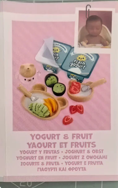 A DIY kit featuring a baby doll and miniature food accessories for yogurt and fruit