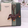 A light beige and olive green PU leather pouch with a brown dachshund keychain charm.