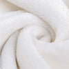 A close-up of a white fade-resistant plush throw blanket rolled into a spiral.