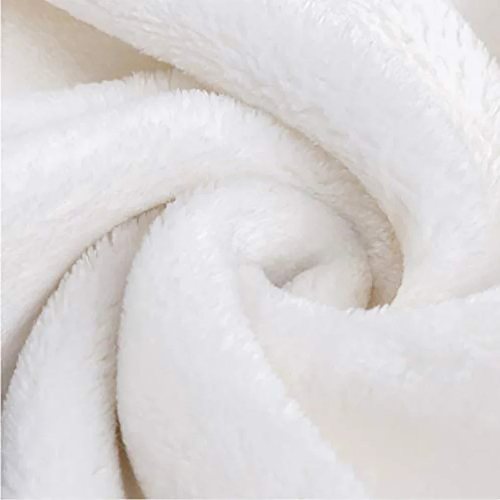 A close-up of a white fade-resistant plush throw blanket rolled into a spiral.