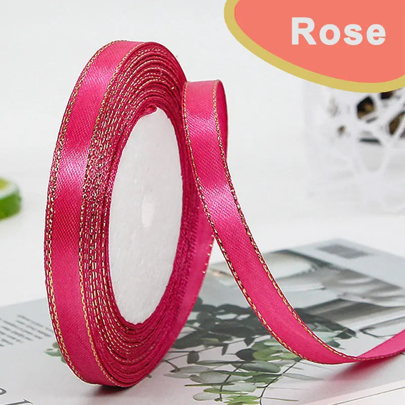 Roll of bright pink gold-edge satin ribbon for crafts and gift wrapping