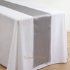 Elegant satin table runner in gray and white on a white tablecloth.