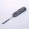 A gray flexible microfiber duster with a handle and dense bristles is shown against a white background.