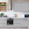 Modern kitchen cabinet and wall unit featuring matte gray cabinetry, white subway tile backsplash, and stainless steel hood.