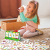 A young girl is holding and examining cards with letters and words on them, demonstrating English learning.