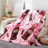 A pink throw blanket featuring a repeating pattern of Dr. Pepper bottles tied with pink ribbons.