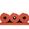Rolls of red silicone heat-resistant craft mat material stacked on a surface