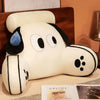 A white plush cat and dog backrest cushion resting on a wooden surface.