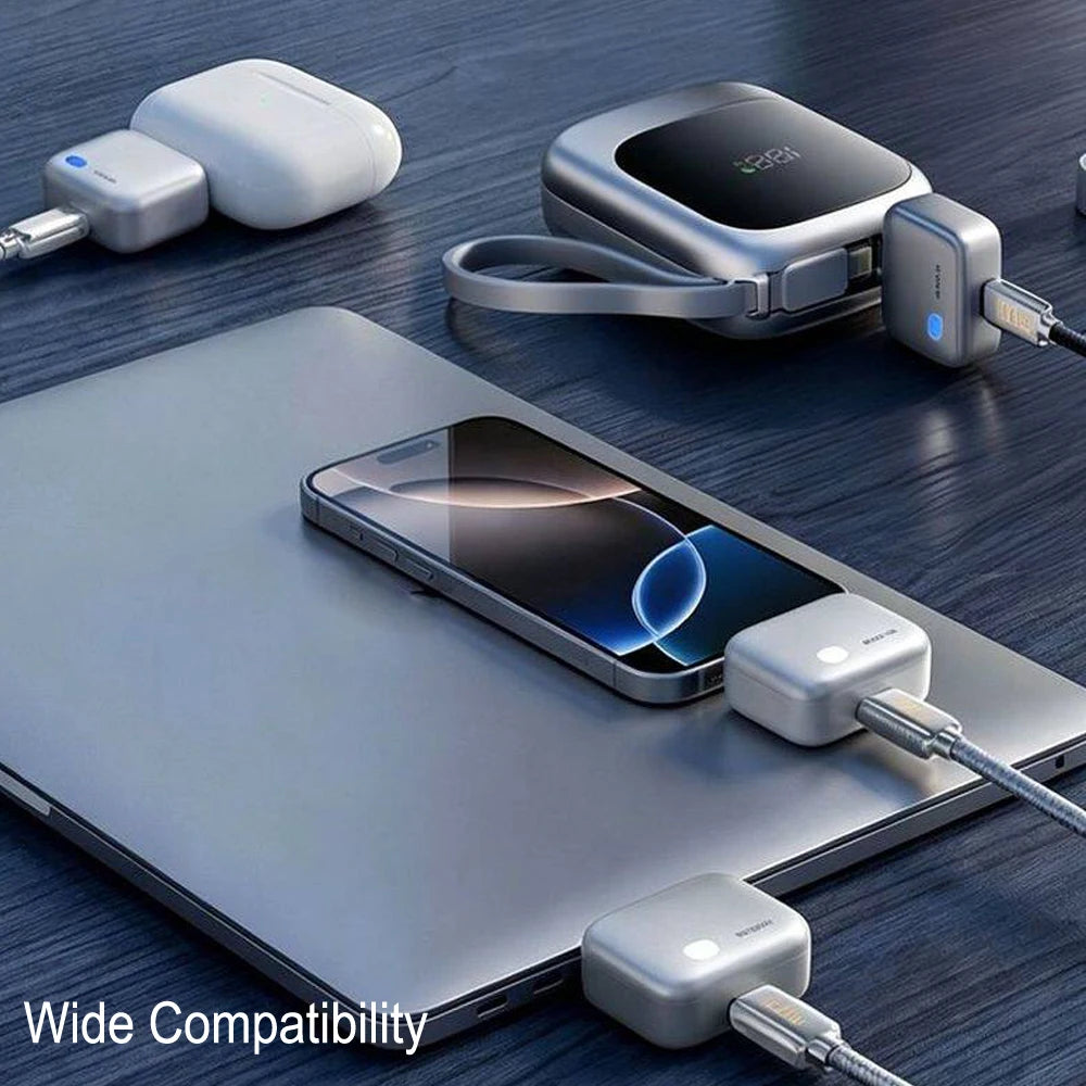 A silver laptop is shown with a mobile phone charging via a wireless adapter and a separate power bank.