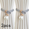 A set of two pearl and rope curtain tie-backs with gold accents shown against a light fabric background.