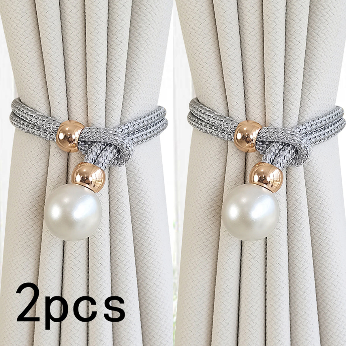 A set of two pearl and rope curtain tie-backs with gold accents shown against a light fabric background.