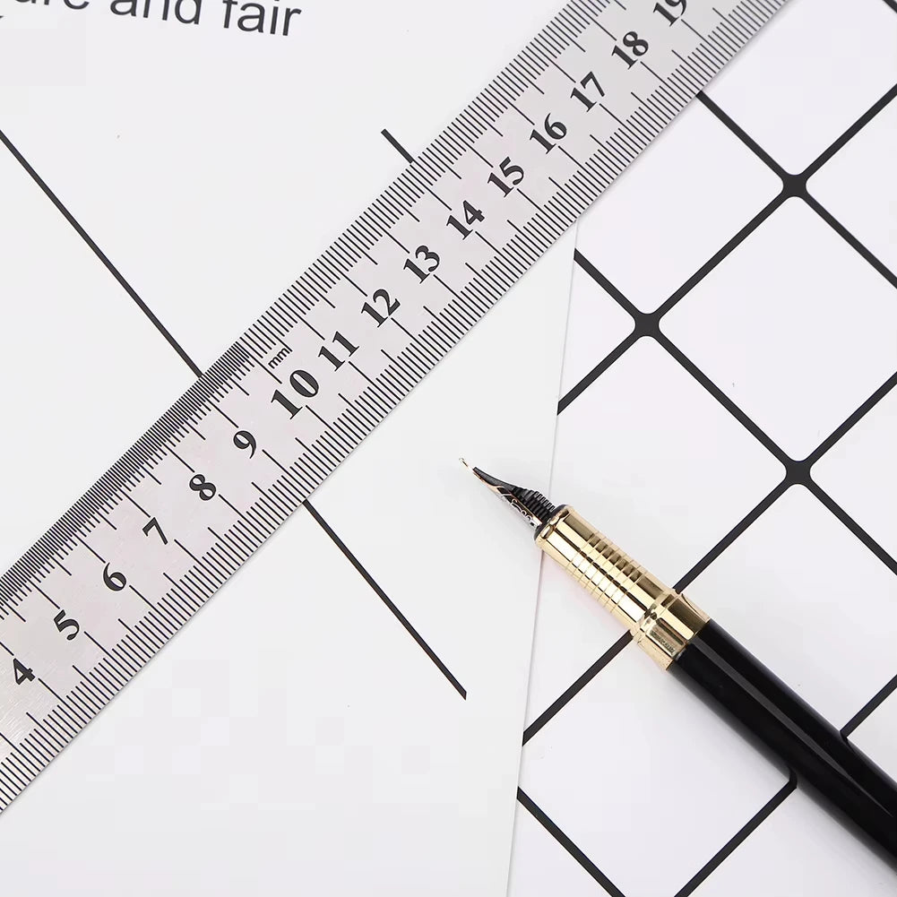 A black pen is placed next to a stainless steel double-sided precision ruler marked in millimeters.