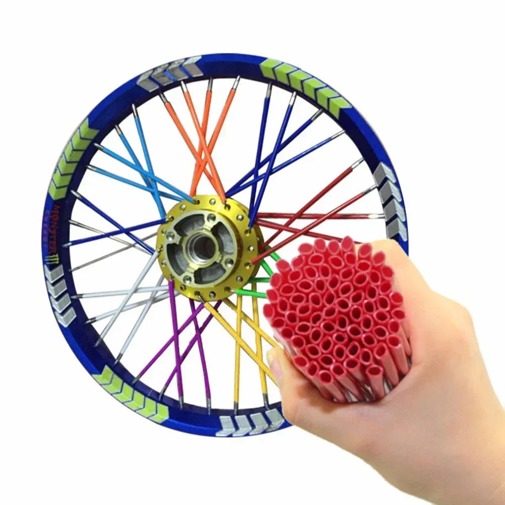A hand holds a motorcycle wheel with colorful spokes and a red protective wrap set.