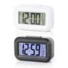 A white compact LED digital alarm clock displaying 12:00, shown in a side view.