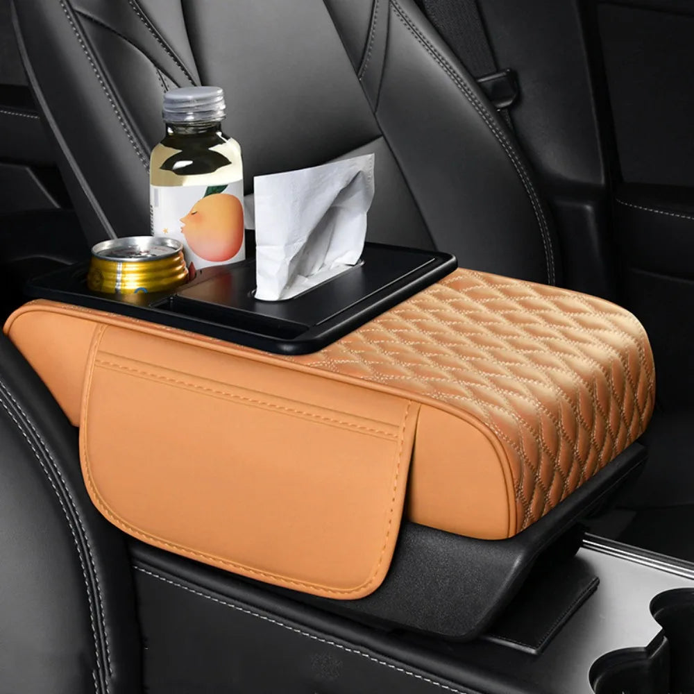 A tan quilted car armrest cushion with storage and cup holders placed on a black car seat.