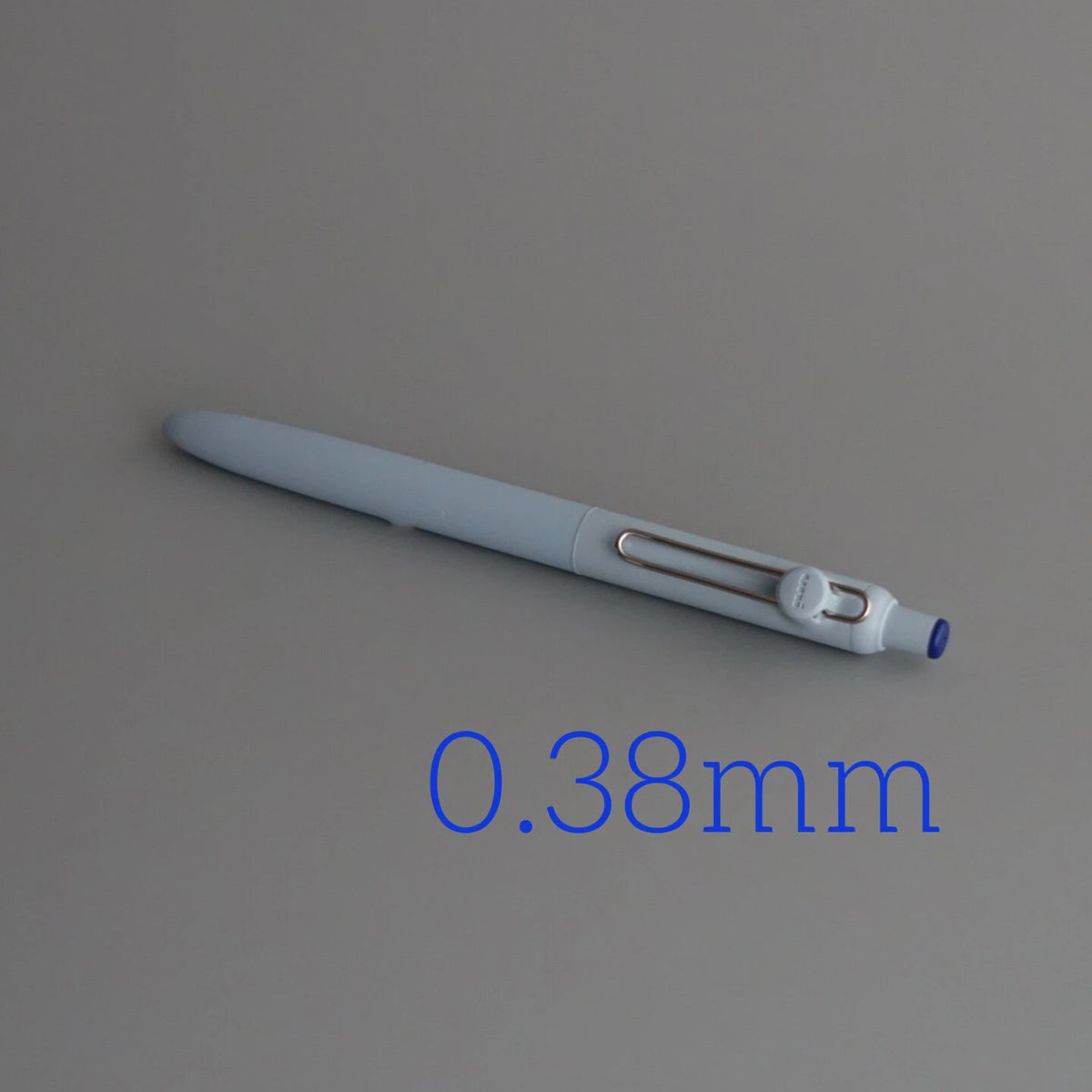 A close-up view of a light gray Uni ZENTO Quick-Dry Gel Pen with a 0.38mm tip.