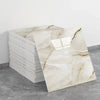 A rectangular panel of white marble effect wall sticker displayed next to a stack of white tiles.