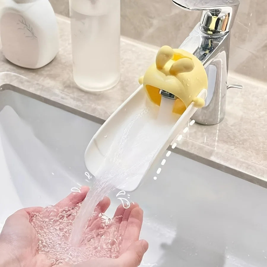 A hand is using a rabbit-themed anti-splash faucet extender to dispense water into a sink.