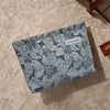 A canvas charger storage pouch with a gray and white floral pattern resting on a beige surface.