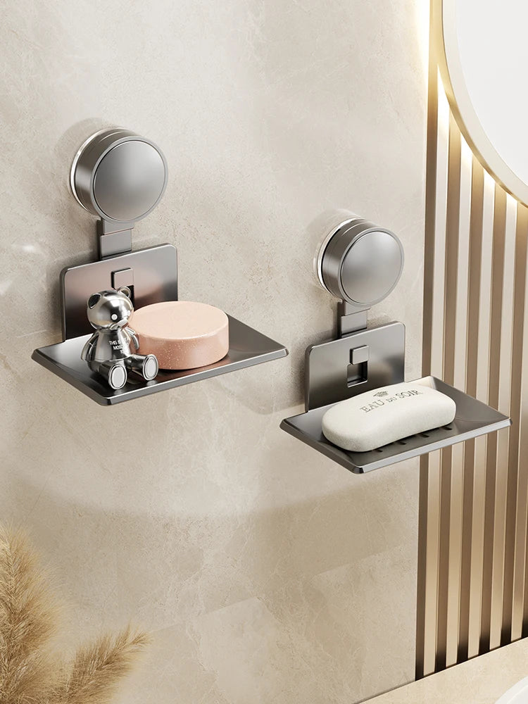 A silver wall-mounted soap dish with a suction cup holder and drain is installed on a beige wall.