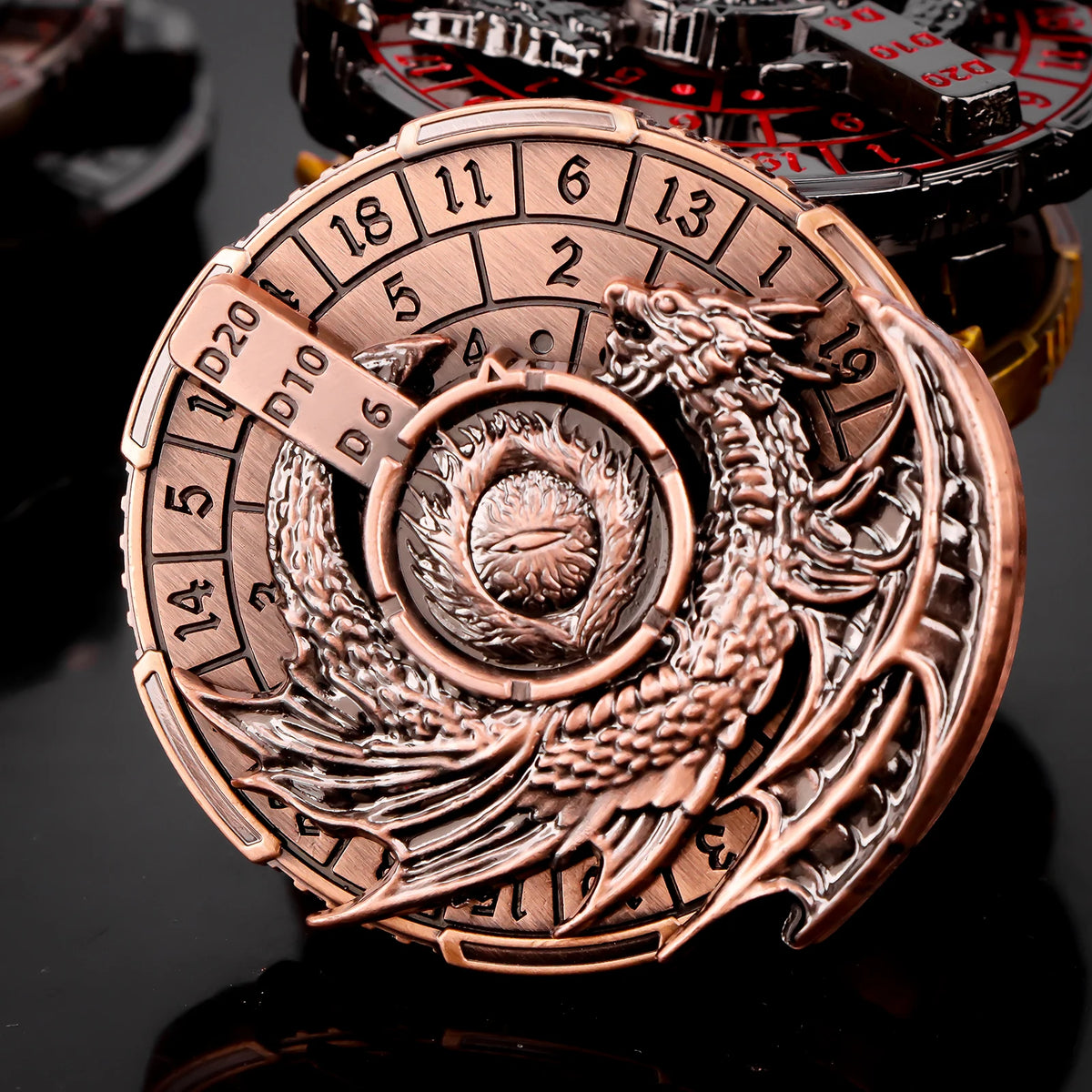 A close-up of a bronze metal spinner dice cube featuring a dragon emblem and numbered faces.
