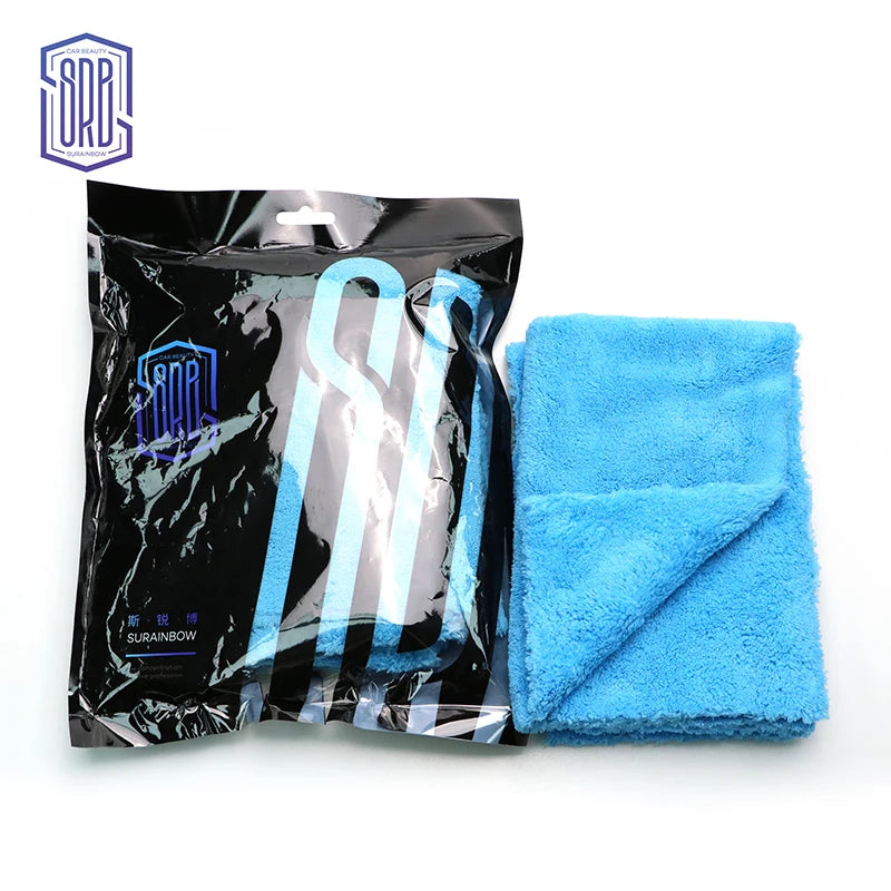 A black package of blue microfiber cleaning cloths with a light blue towel visible beside it.