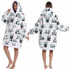 Eine Frau modelliert einen weißen, patchwork-großen Fleece-Hoodie mit schwarzem Panda-Print auf der Vorderseite und Kapuze.