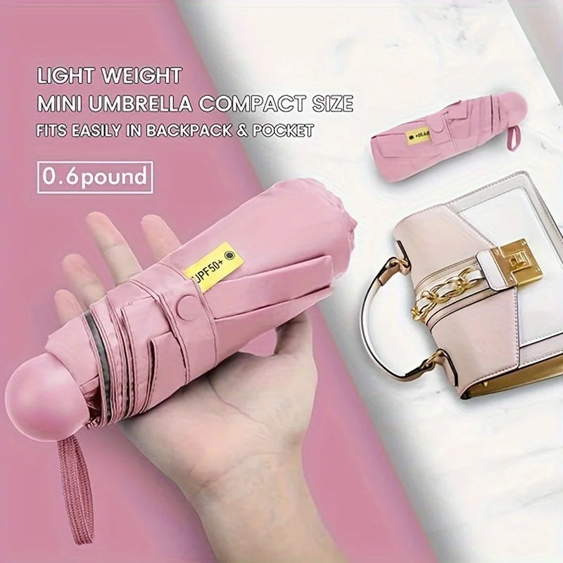 A pink mini umbrella is shown being held in a hand next to a cosmetic bag and a white marble background.