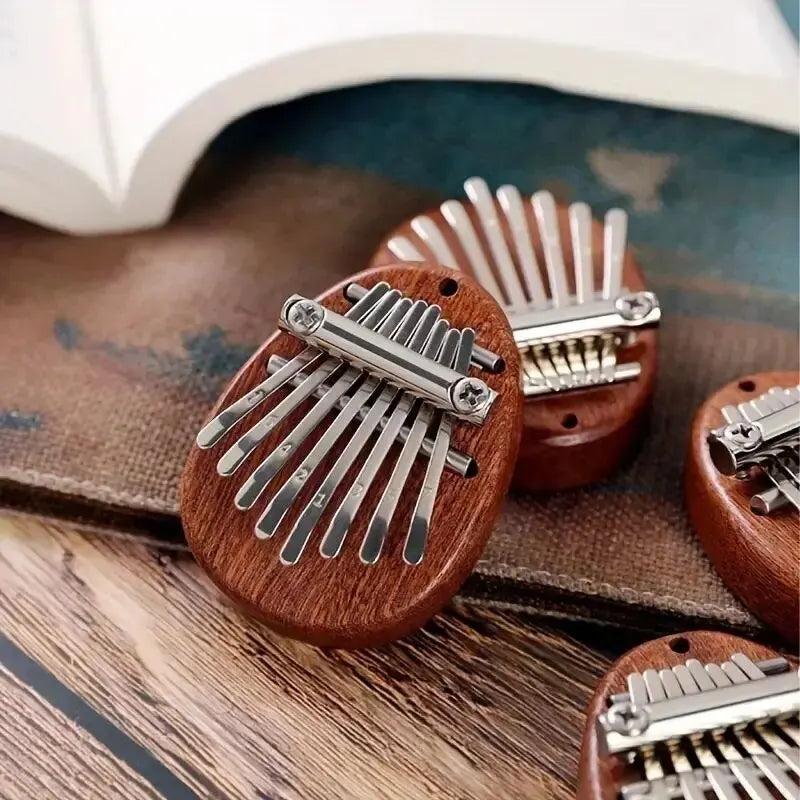 A close-up of a wooden kalimba thumb piano with metal tines resting on a brown fabric surface.